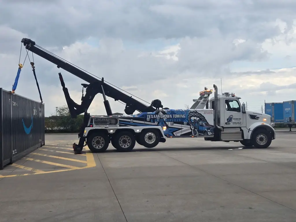 Rotator boom fully extended over a shipping container with outriggers deployed