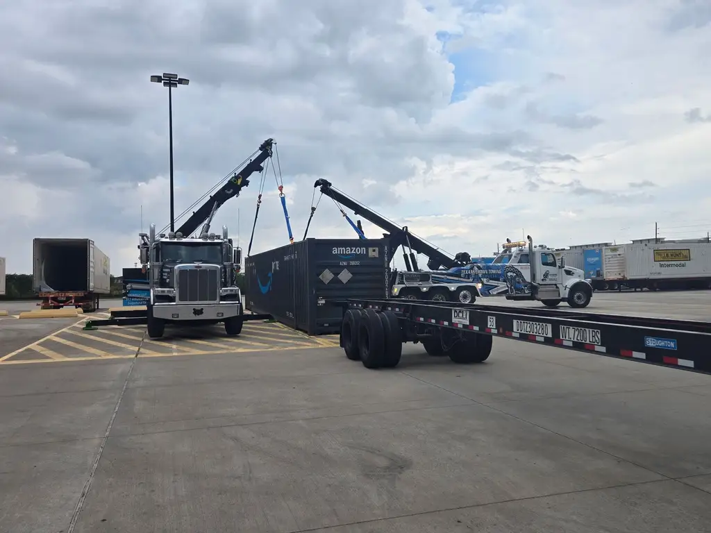 Empty container chassis in the foreground while the rotator holds the container