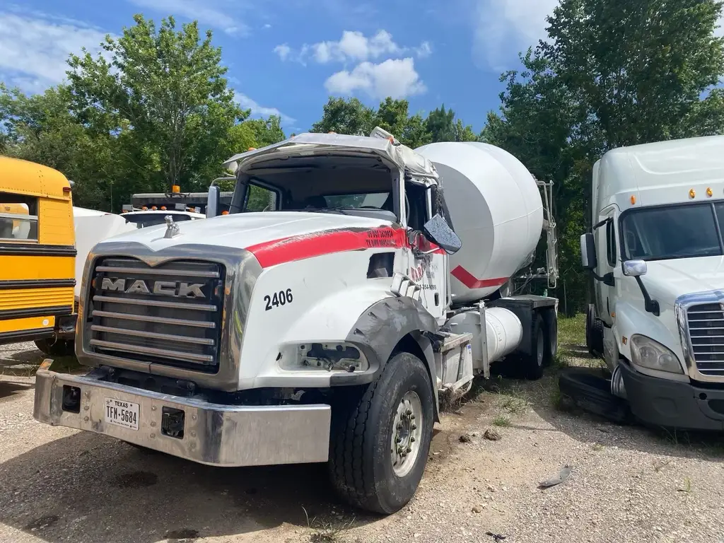 Front view of a rolled cement mixer truck showing cab damage