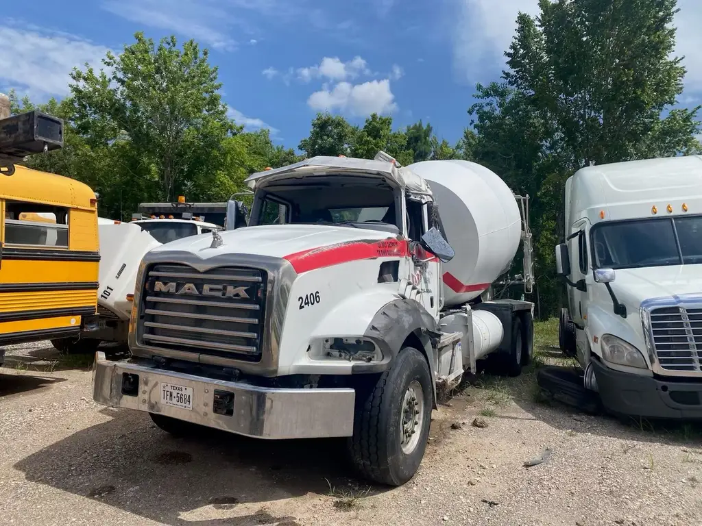 Cement mixer truck with rollover damage parked in the storage yard