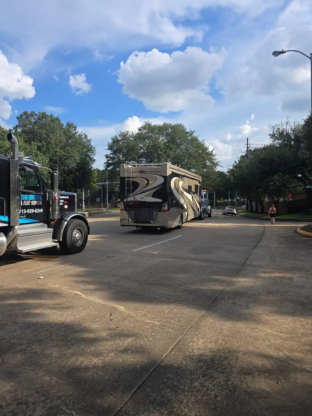 Wide view of the rotator and a Class A motorhome on a tree-lined street
